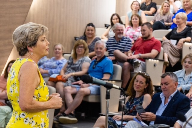 Colleen in front of a crowd explaining lifes opportunities. Colleen in front of a crowd explaining lifes opportunities.